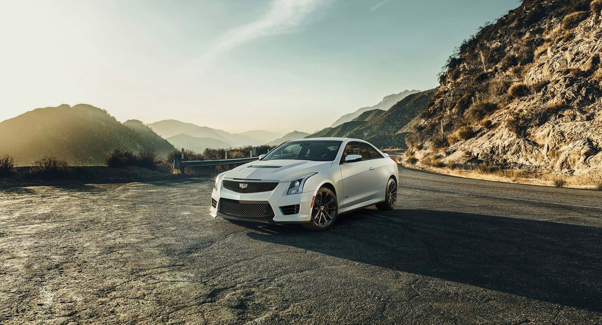 Sleek Cadillac Ats Driving On A Coastline Road Wallpaper