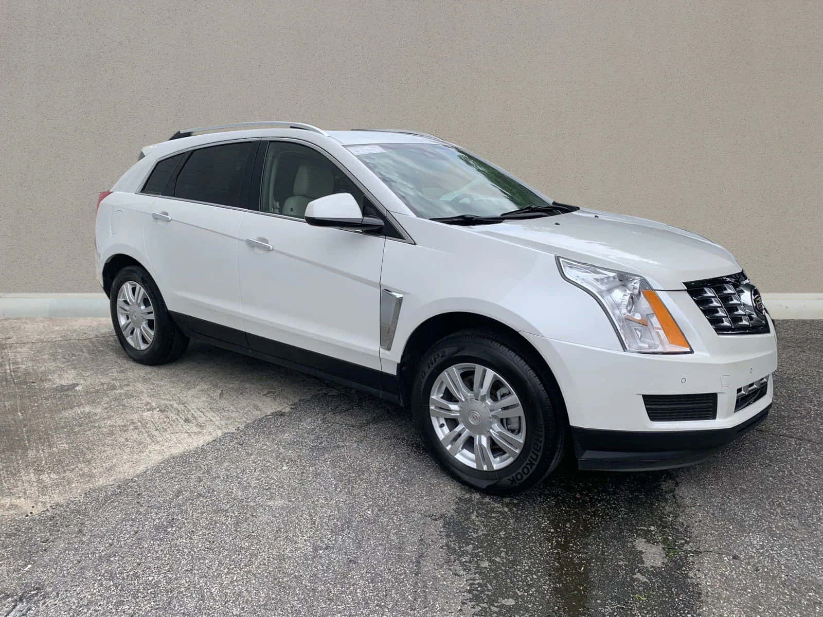 Sleek Cadillac Srx On The Road Wallpaper