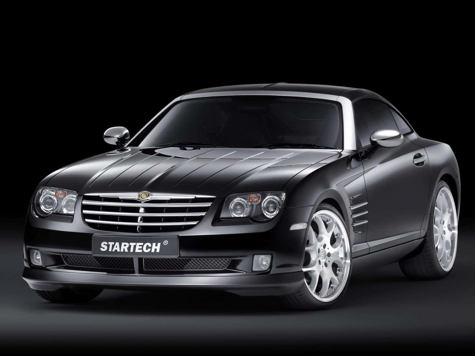 Sleek Chrysler Crossfire On A Scenic Road Wallpaper