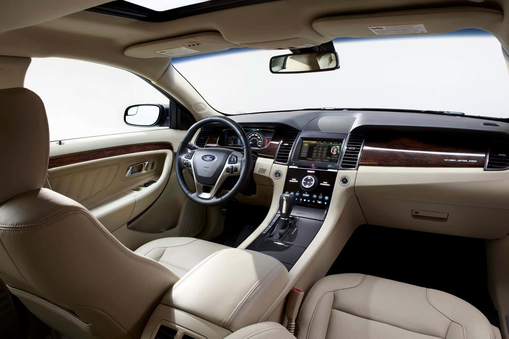 Sleek Ford Taurus Driving On A Picturesque Road Wallpaper