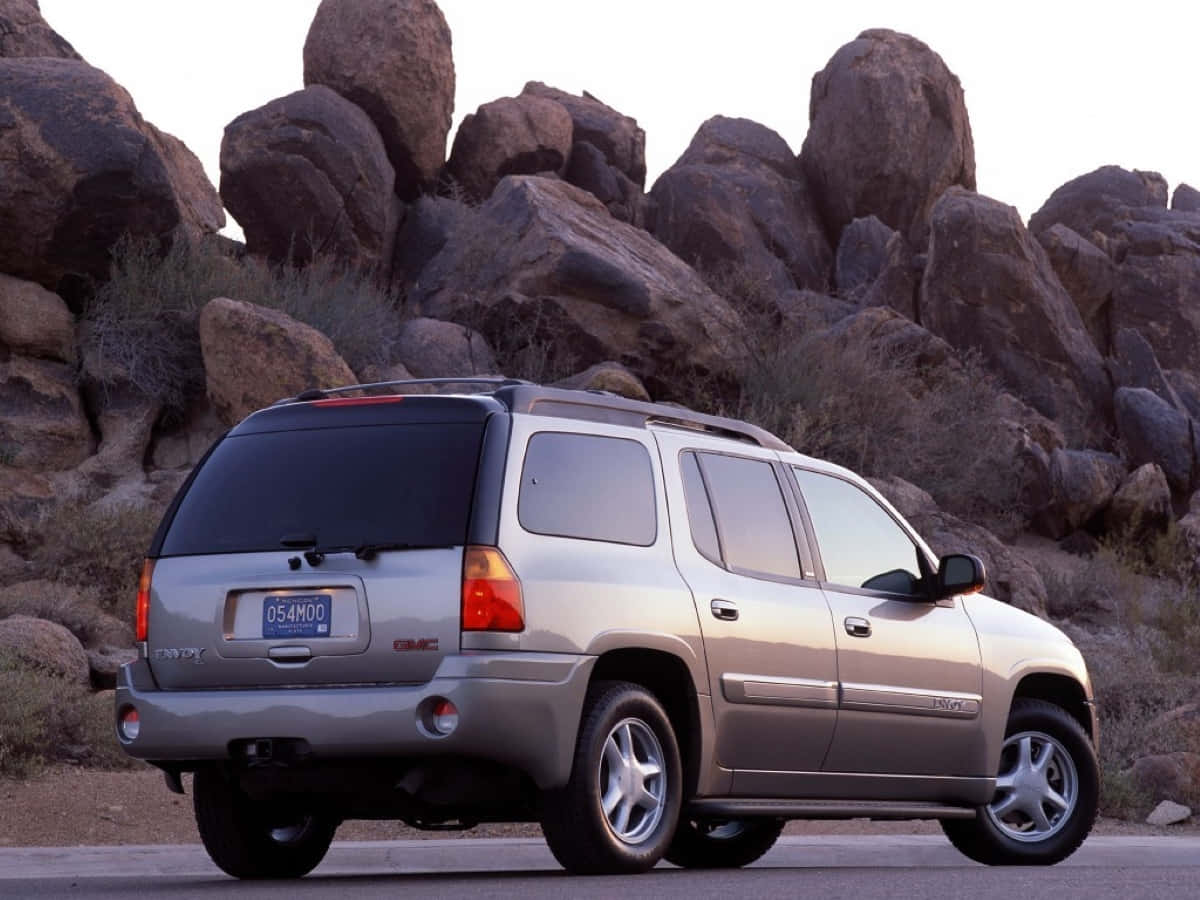 Sleek Gmc Envoy Driving On The Open Road Wallpaper