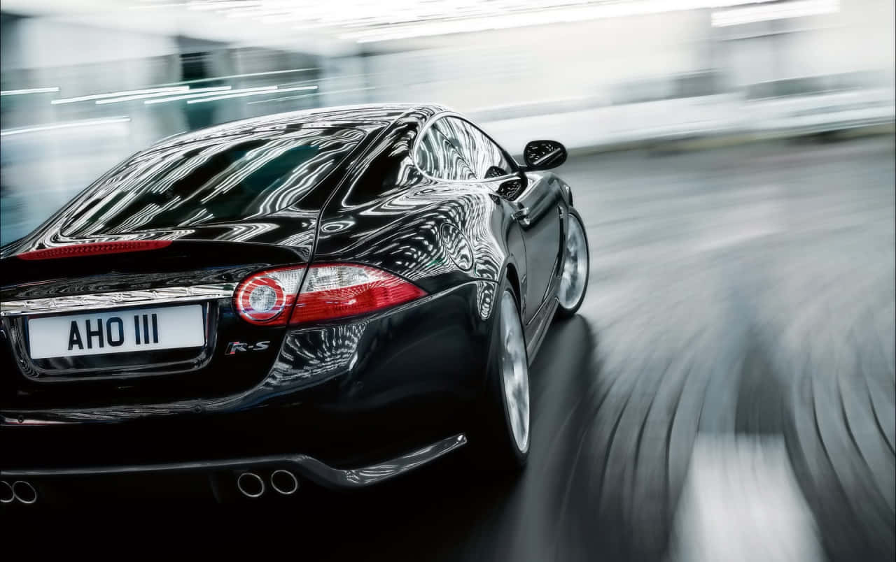 Sleek Jaguar Xkr Sports Car On The Road Wallpaper