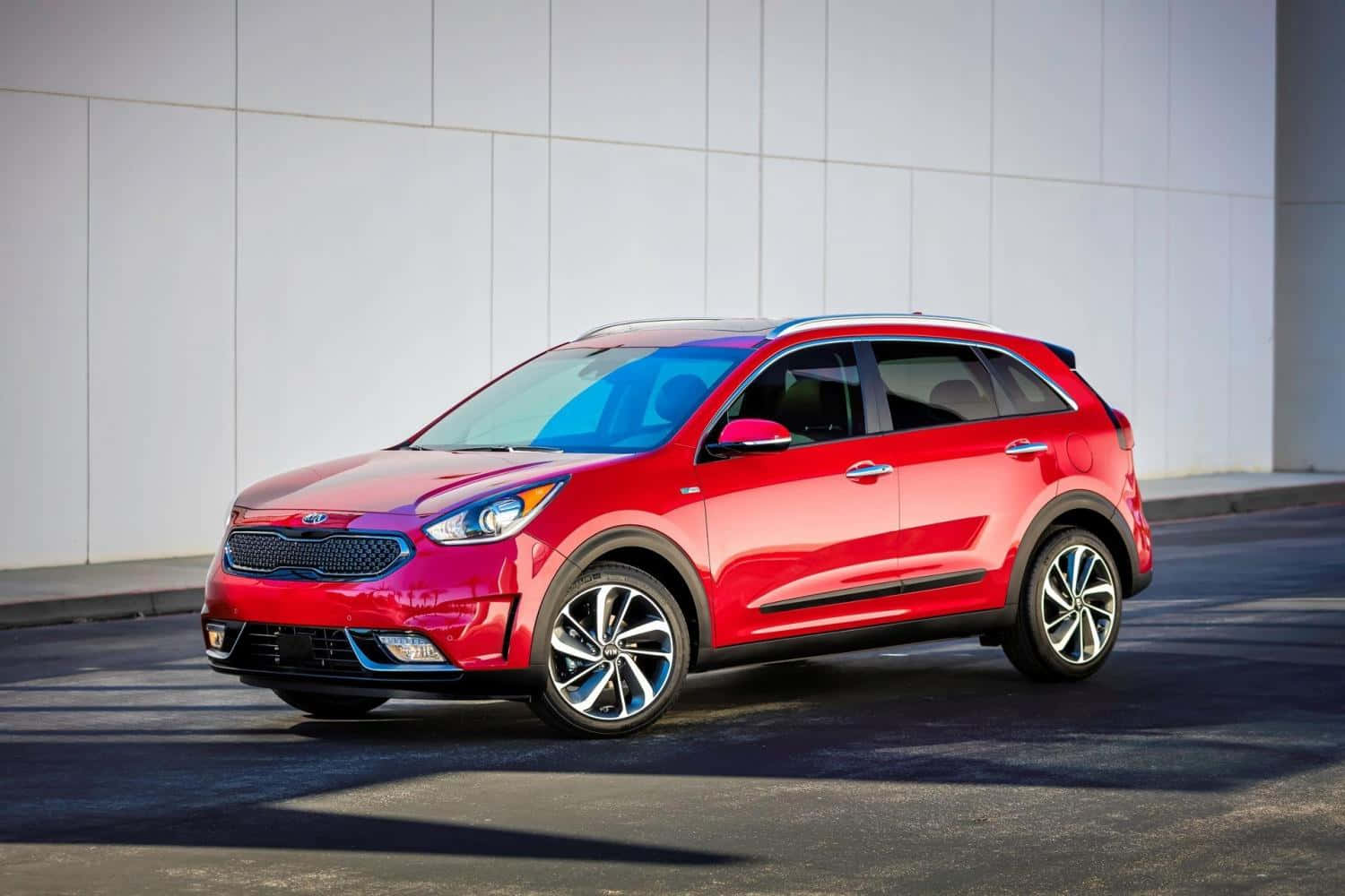 Sleek Kia Niro Driving On A Scenic Road Wallpaper