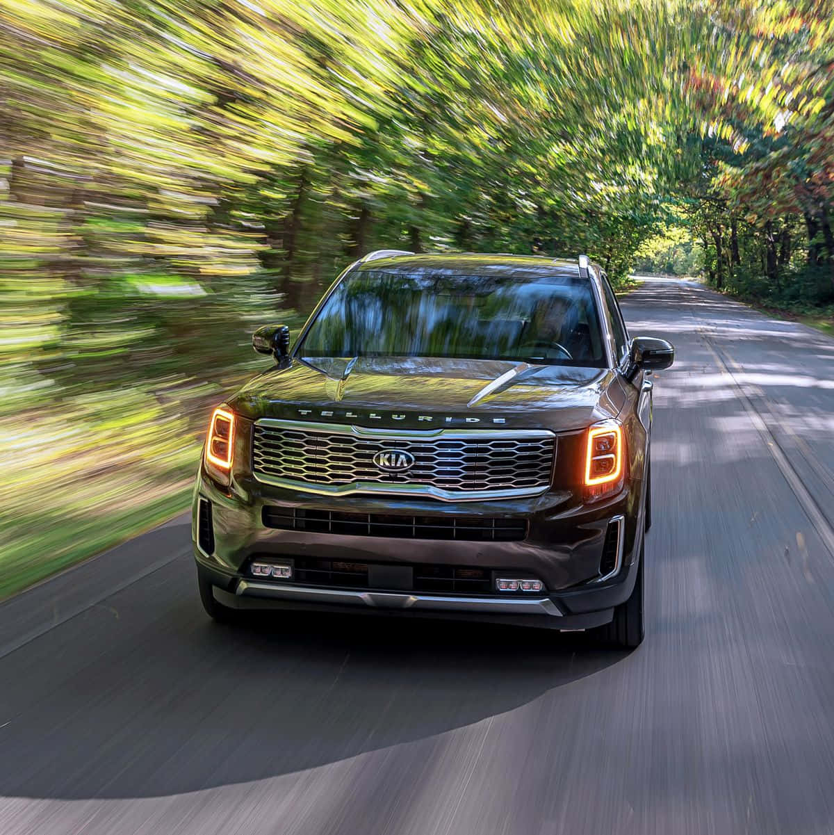 Sleek Kia Telluride Cruising On A Beautiful Highway Wallpaper