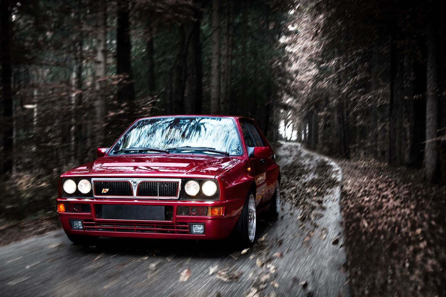 Sleek Lancia Sports Car On A Scenic Road Wallpaper