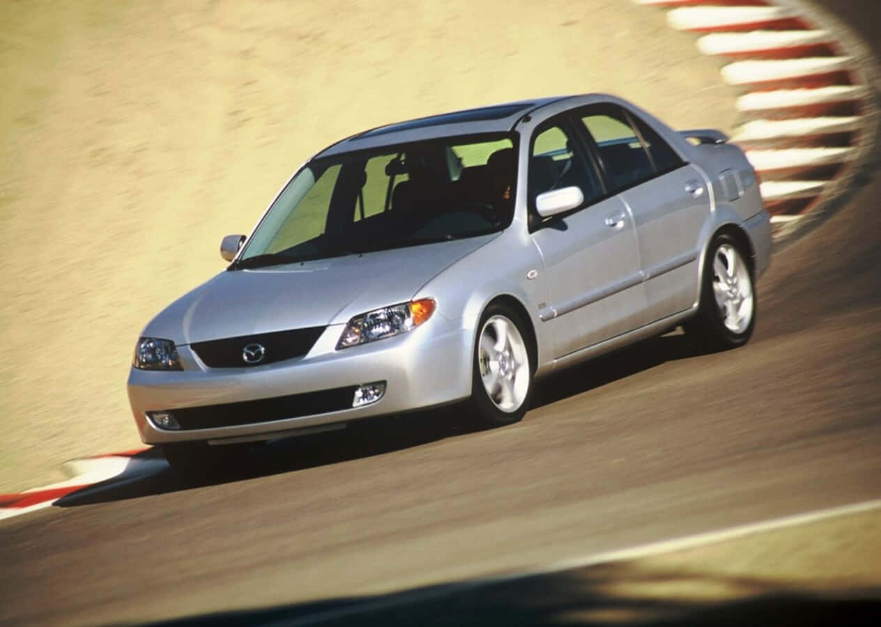 Sleek Mazda Protege In A Stunning Setting Wallpaper