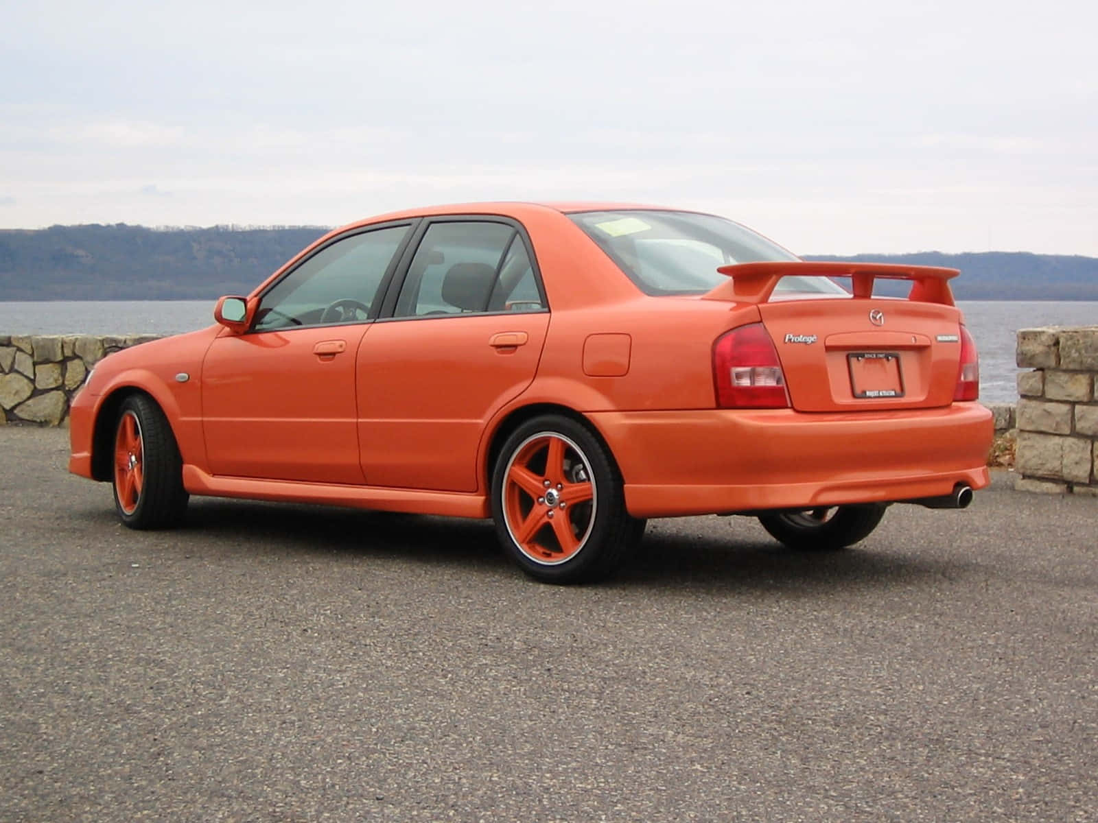 Sleek Mazda Protege In Stunning Sunset Wallpaper