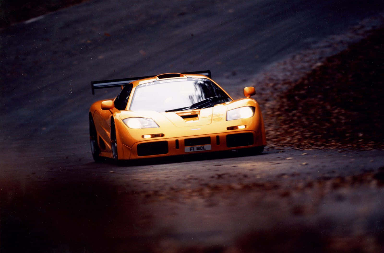 Sleek Mclaren F1 Racing On An Open Road Wallpaper