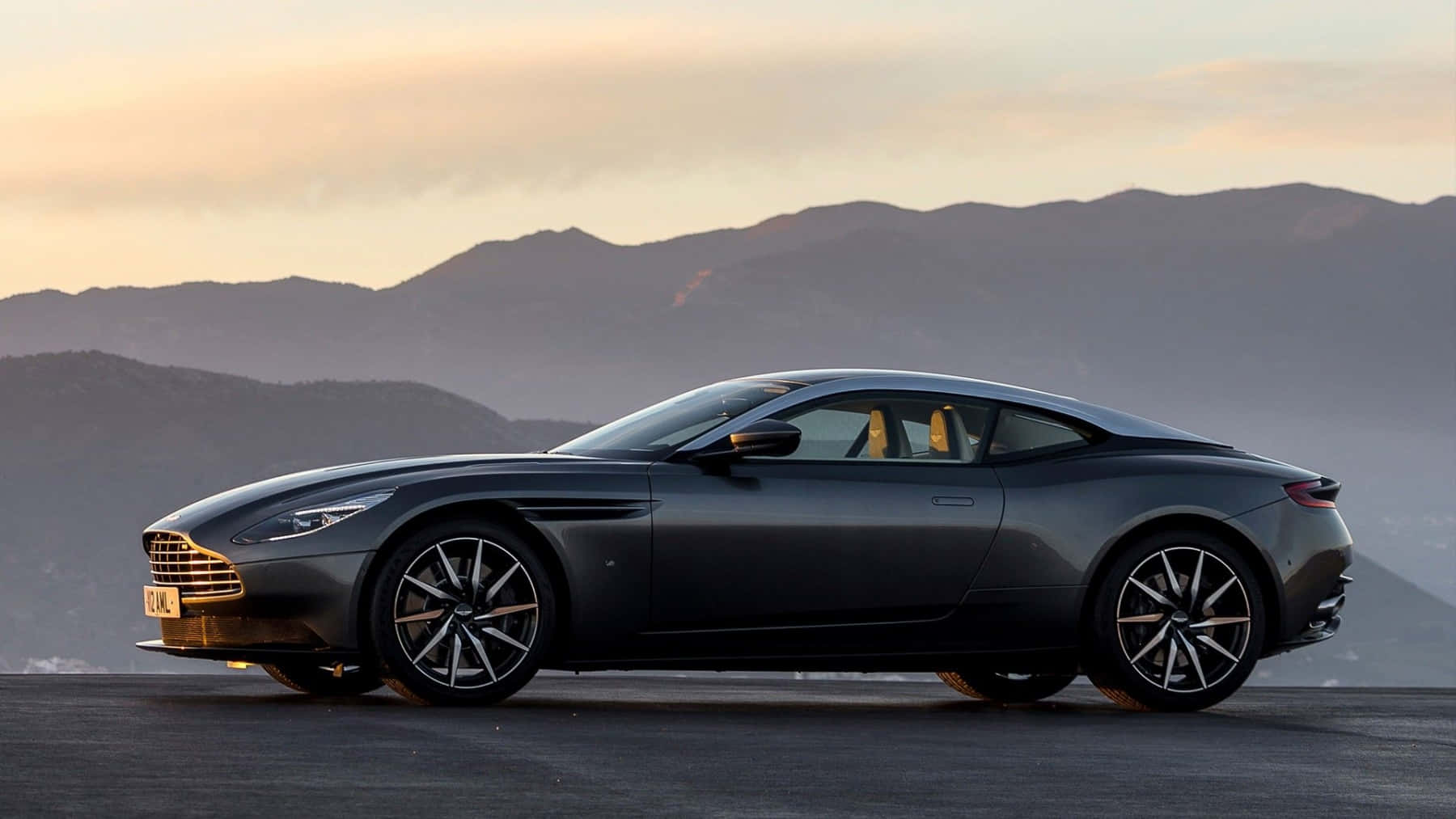 Sleek Metallic Gray Aston Martin Db11 On The Road Wallpaper