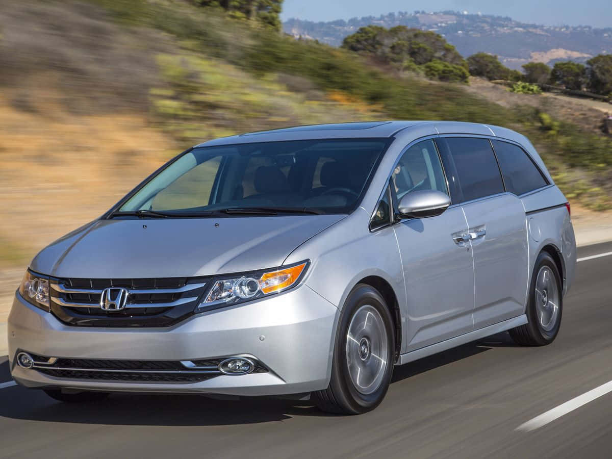 Sleek Silver Honda Odyssey On A Scenic Road Wallpaper