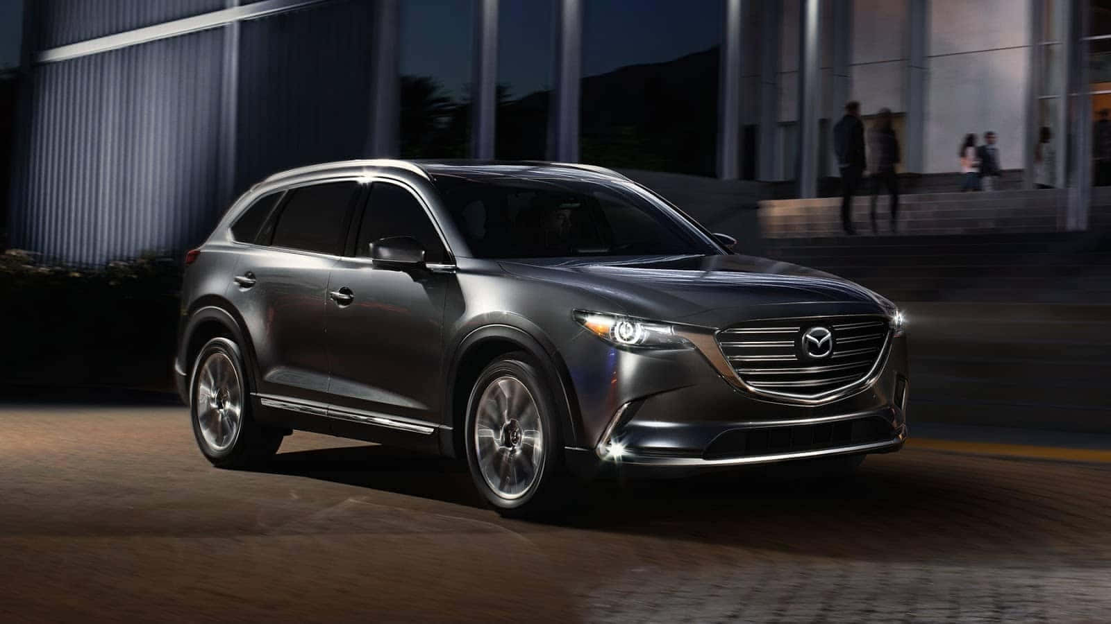 Sleek Silver Mazda Cx-9 On A Scenic Road Wallpaper