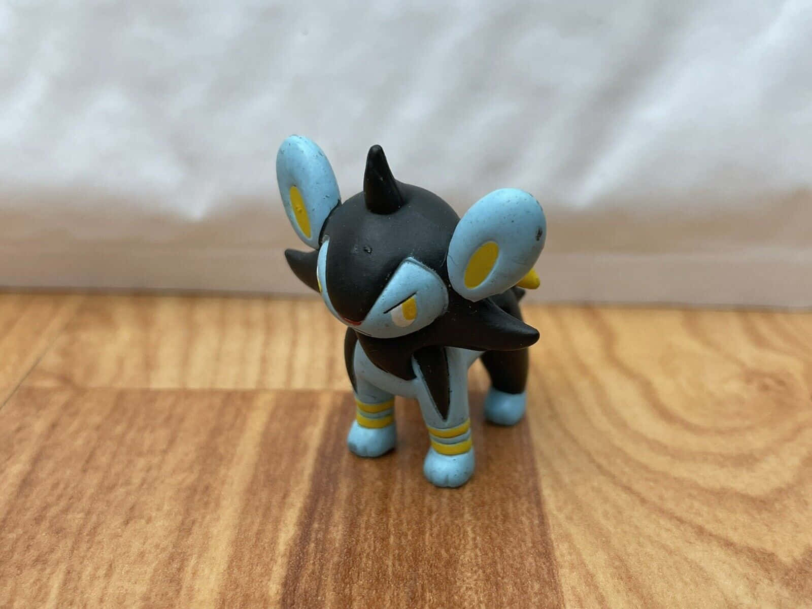 Small Luxio Toy On Wooden Surface Wallpaper