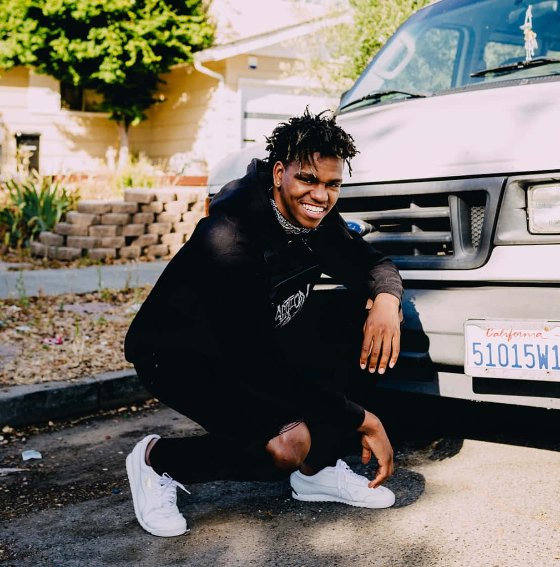 Smiling Man Crouching By Van Wallpaper