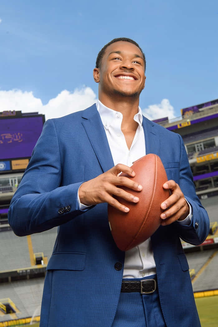 Smiling Man Holding Football Stadium Background Wallpaper