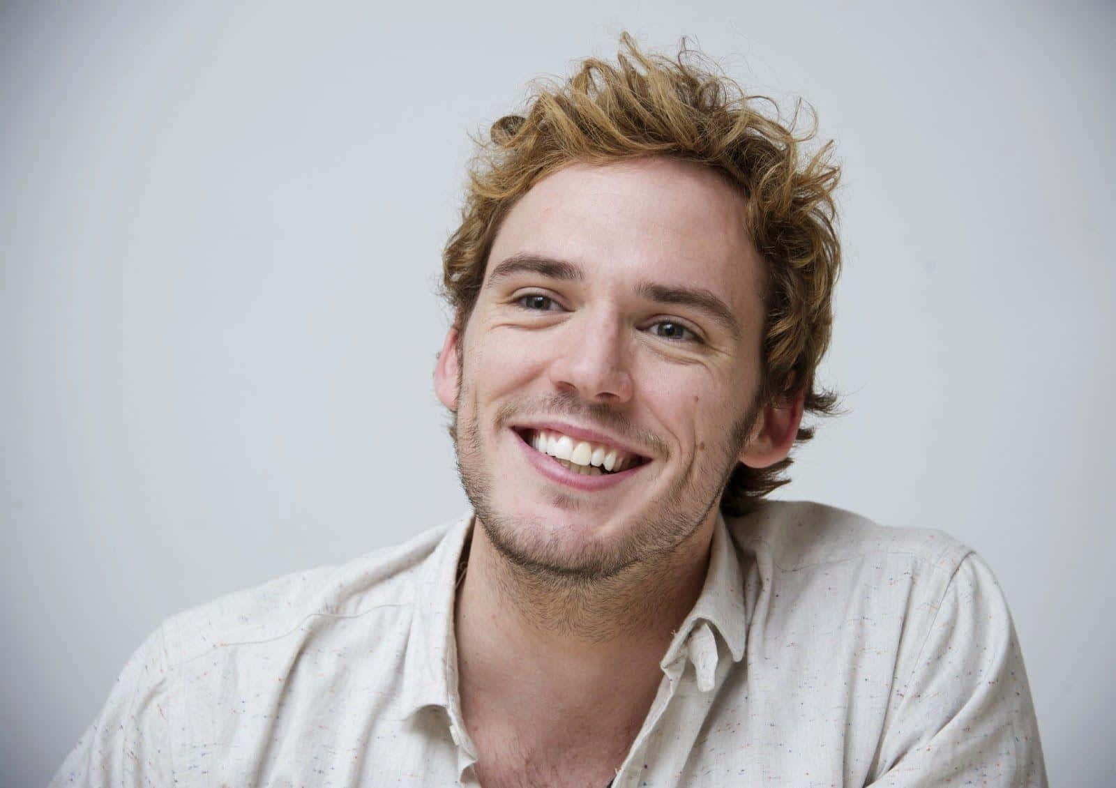 Smiling Portrait Of Actor Sam Claflin Wallpaper