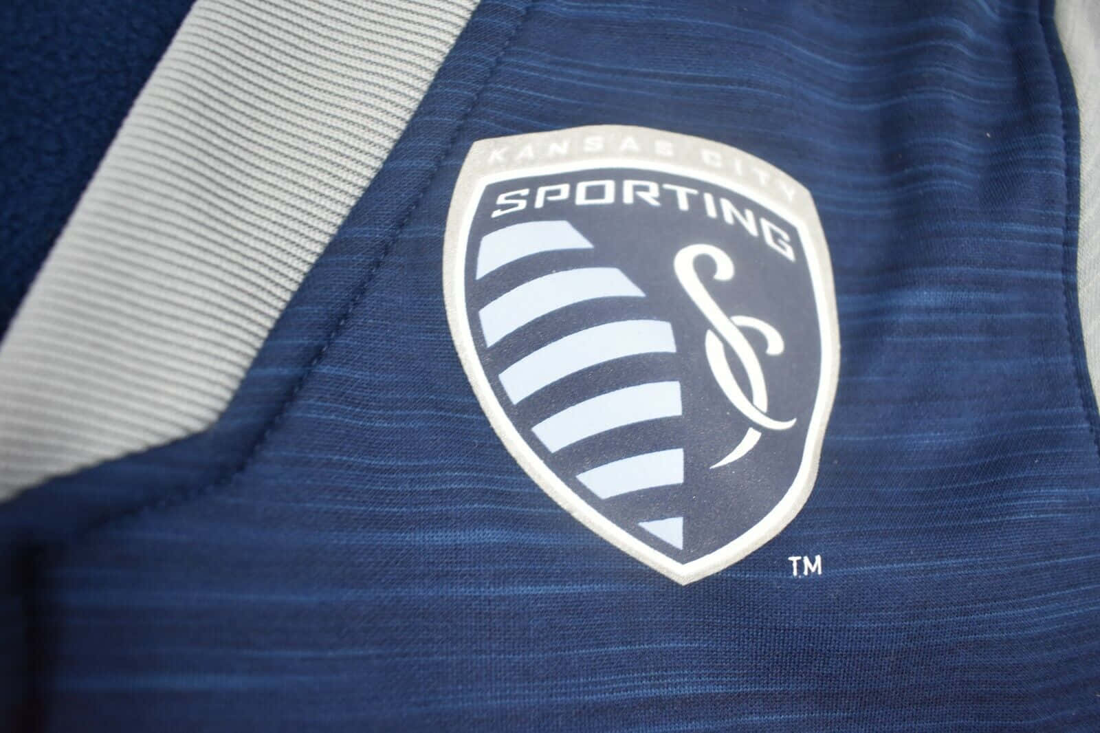 Sporting Kansas City Logo On Blue Grey Jersey Wallpaper