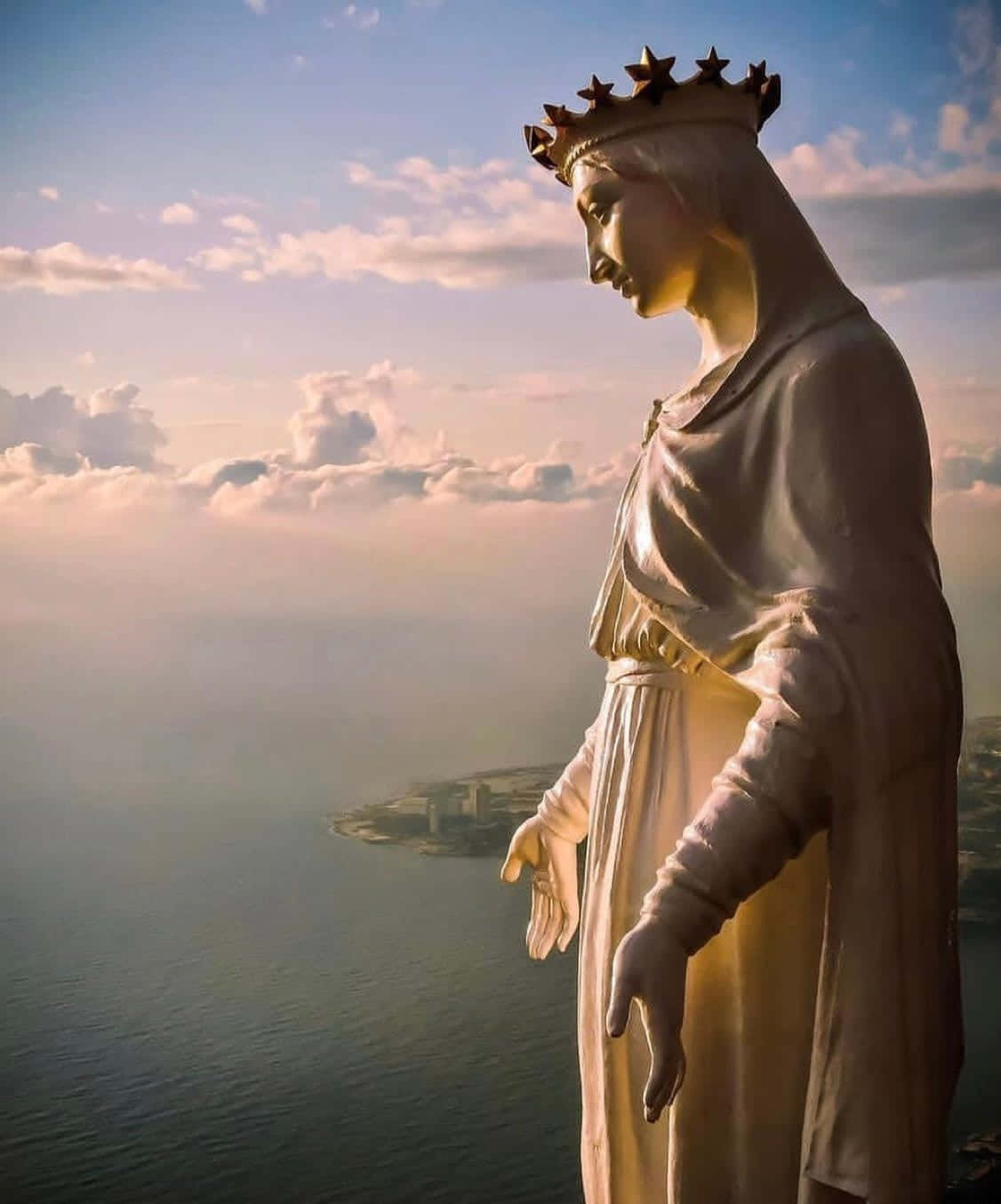 Statue Overlooking Waterfront Sunset Wallpaper