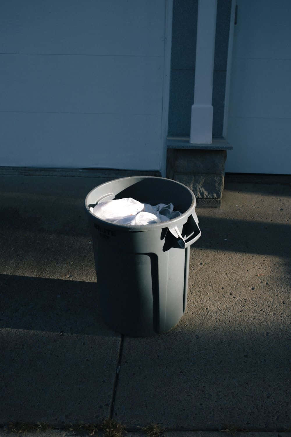 Striking Minimalistic Display Of A Black Plastic Trash Can Wallpaper