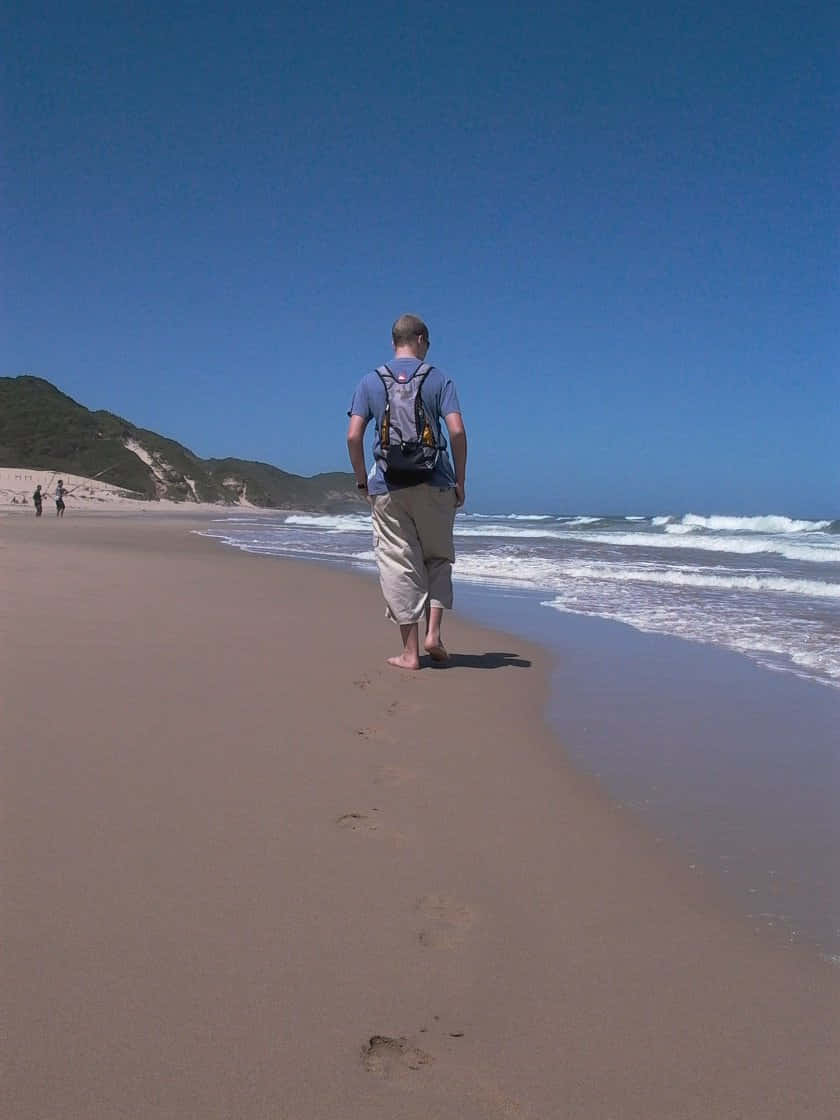 Strolling Along The Sandy Beach Shoreline Wallpaper