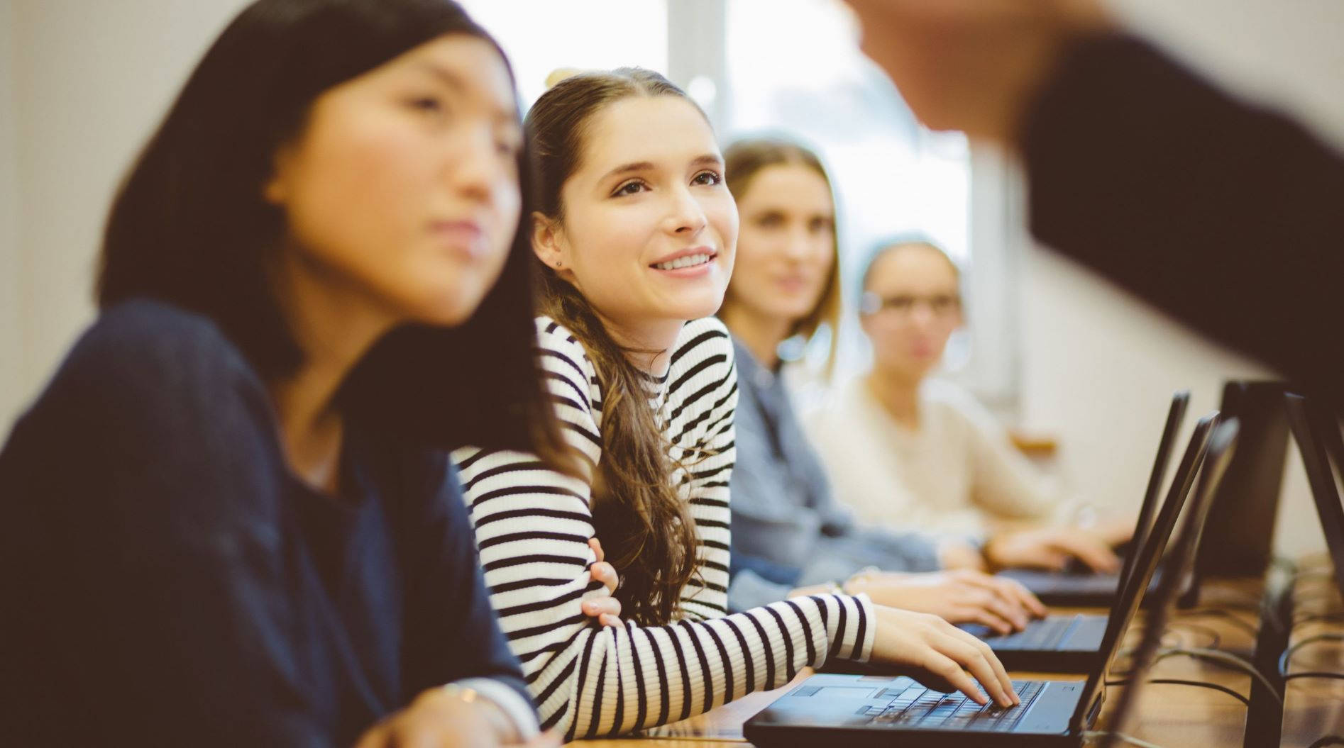 Students Listening To Teacher Using Laptops Wallpaper