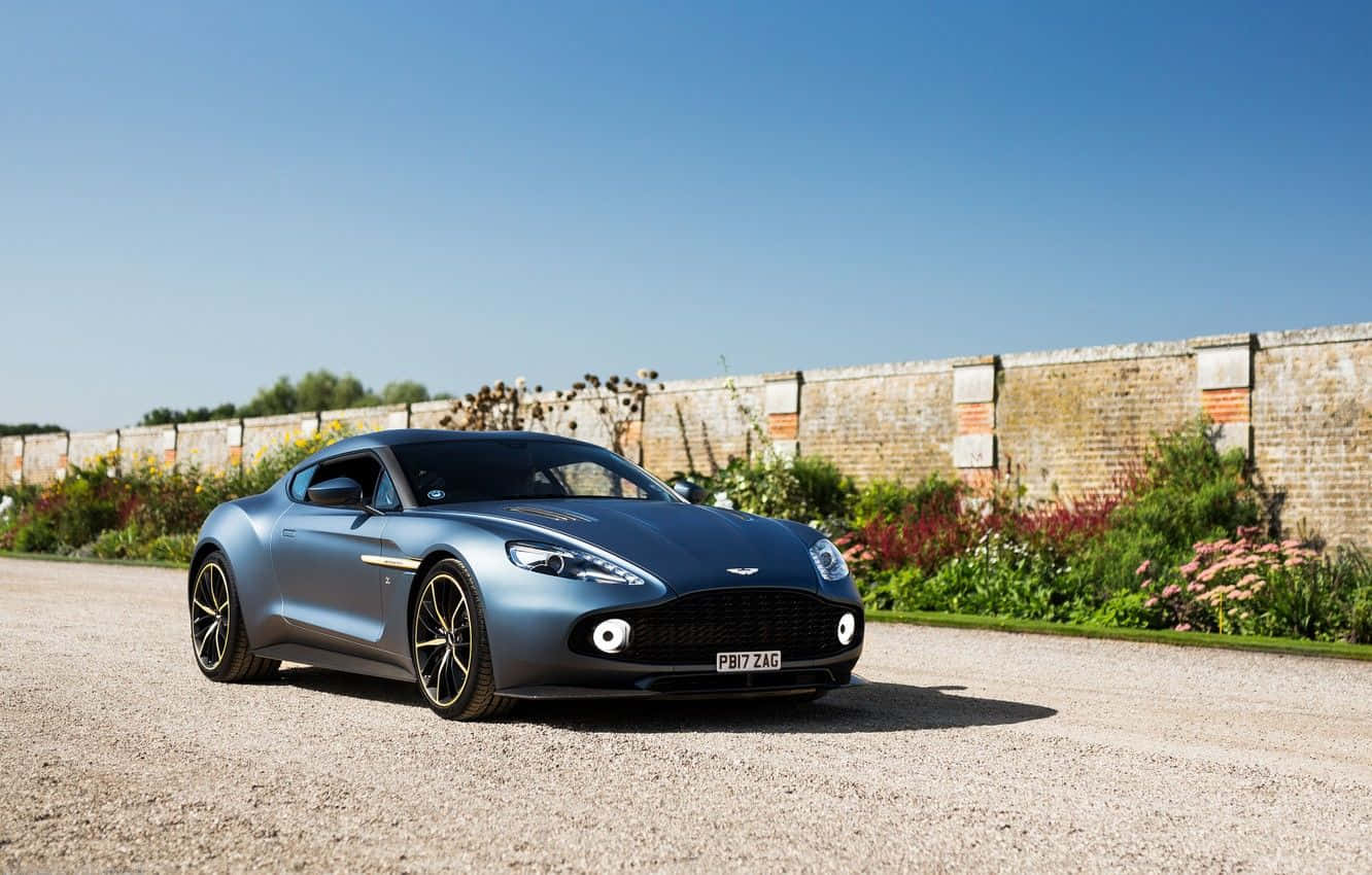 Stunning Aston Martin Vanquish In Motion On A Scenic Road Wallpaper