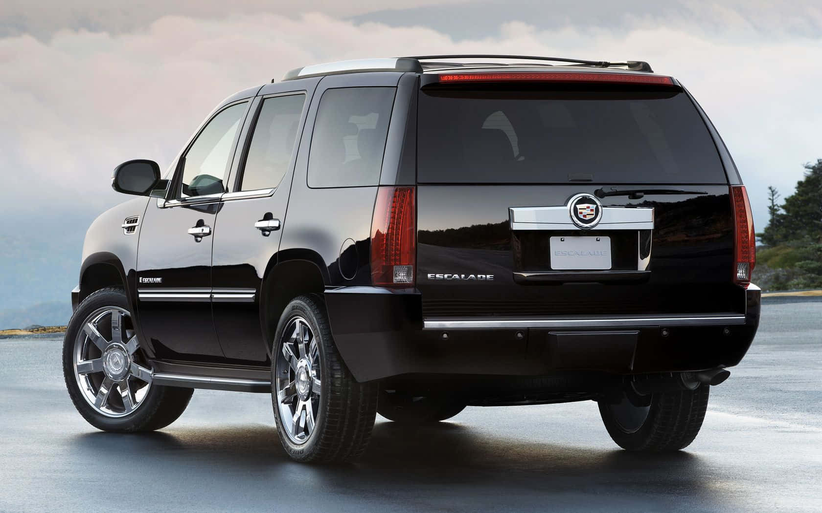 Stylish Cadillac Escalade Parked On City Street Wallpaper