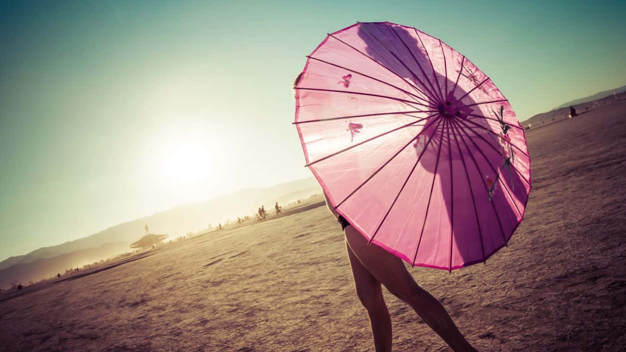 Sunset At The Beach With A Colorful Umbrella Wallpaper