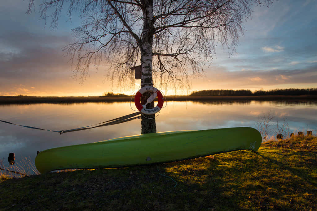 Sunset Canoeby Lakeside Karlstad Wallpaper