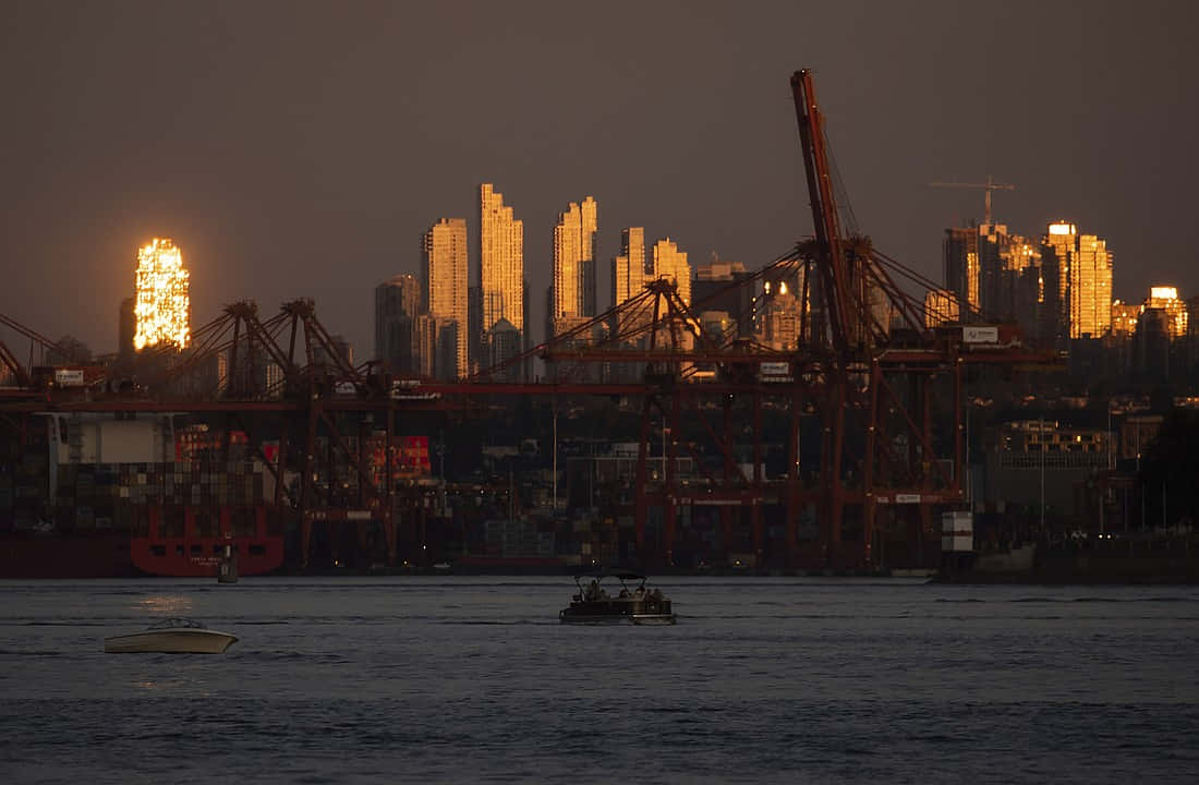 Sunset Glow Over Harbor Cityscape Wallpaper