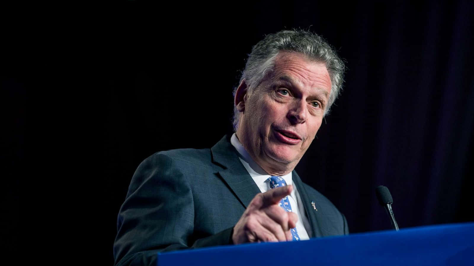 Terry Mcauliffe Delivering A Speech At A Podium Wallpaper