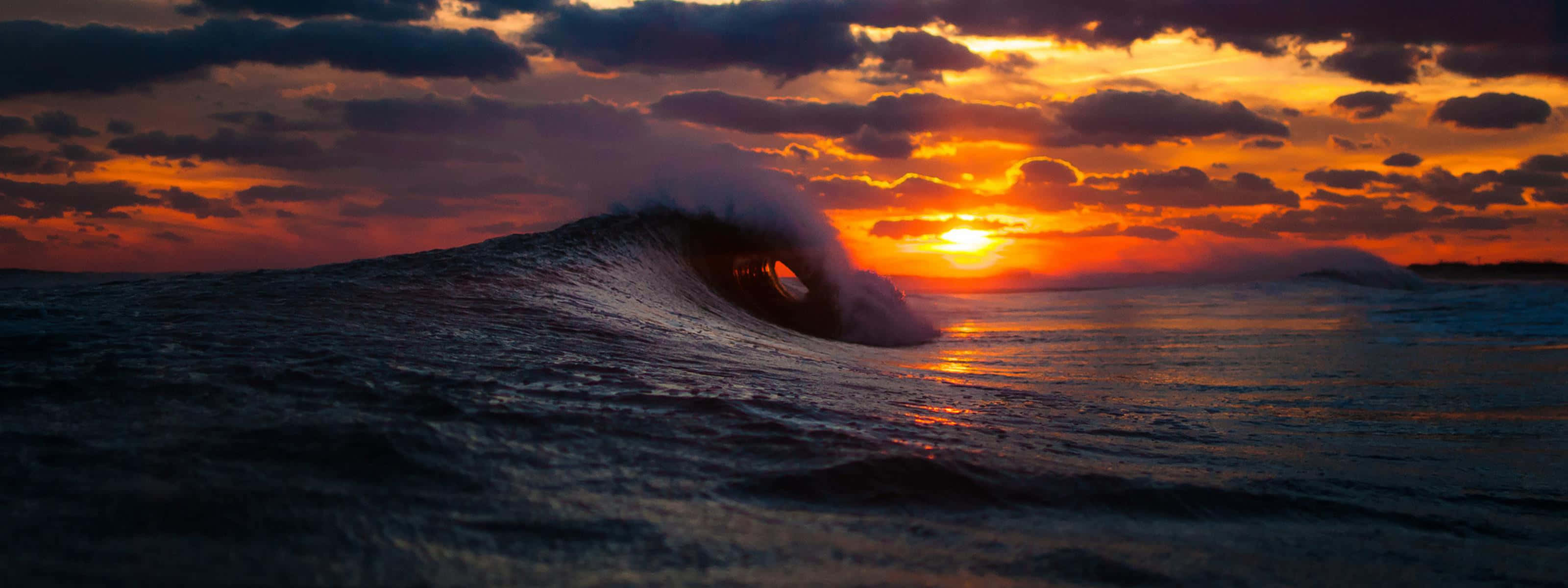 The Beauty Of A Unique Sunset Reflected In The Waves Wallpaper