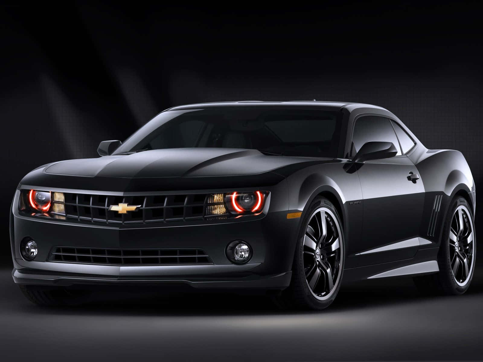 The Black Chevrolet Camaro Is Shown In A Dark Background Wallpaper