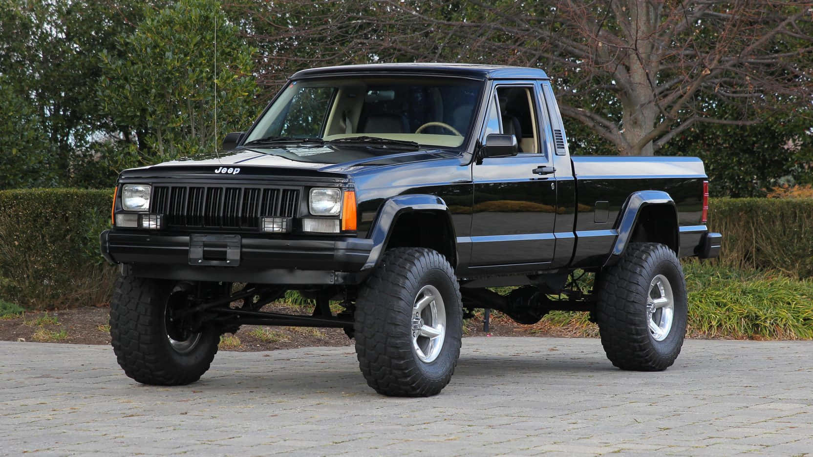 The Classic Jeep Comanche Against A Mountainous Backdrop Wallpaper