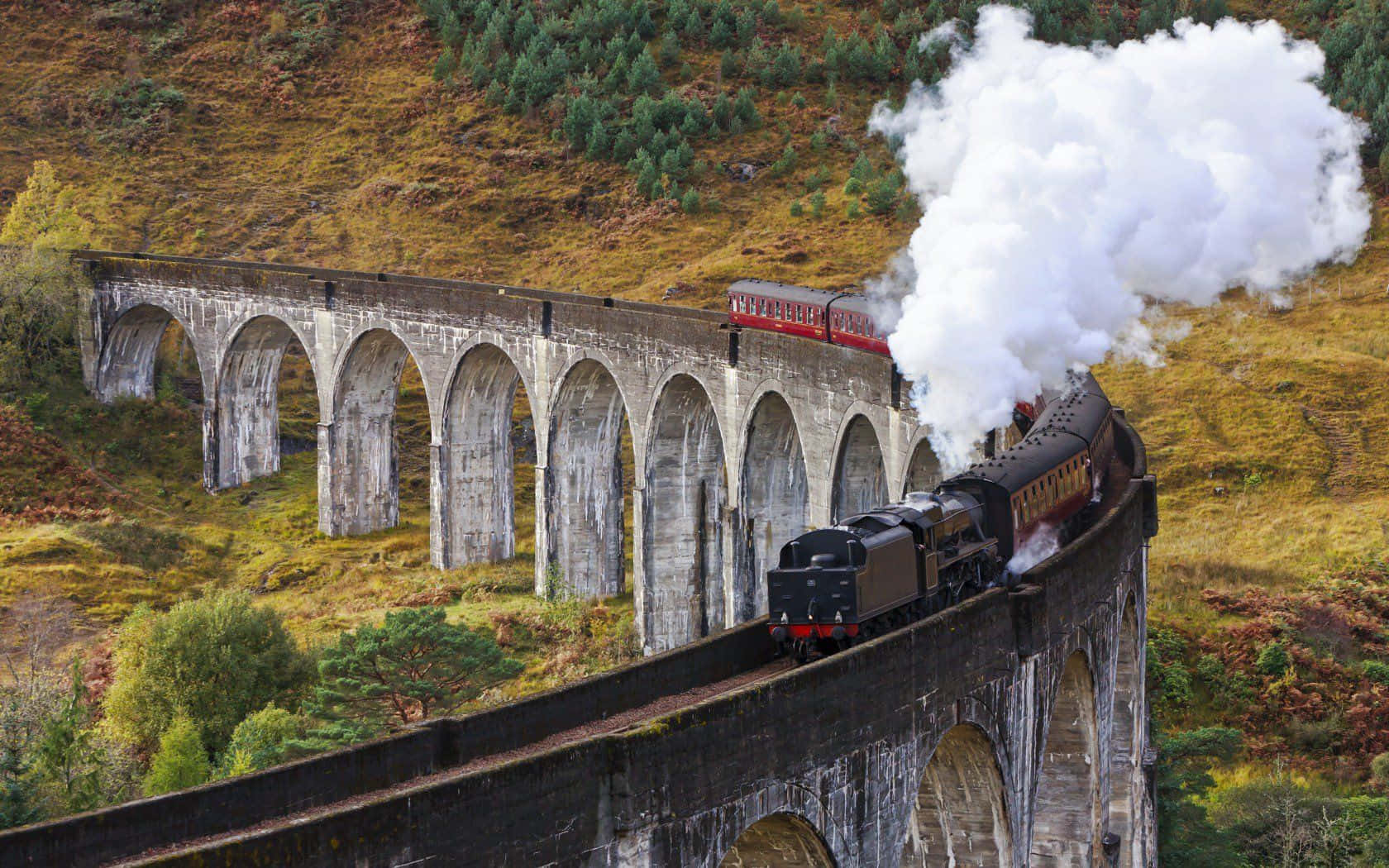 The Iconic Hogwarts Express Train Steaming Through The Misty Countryside. Wallpaper