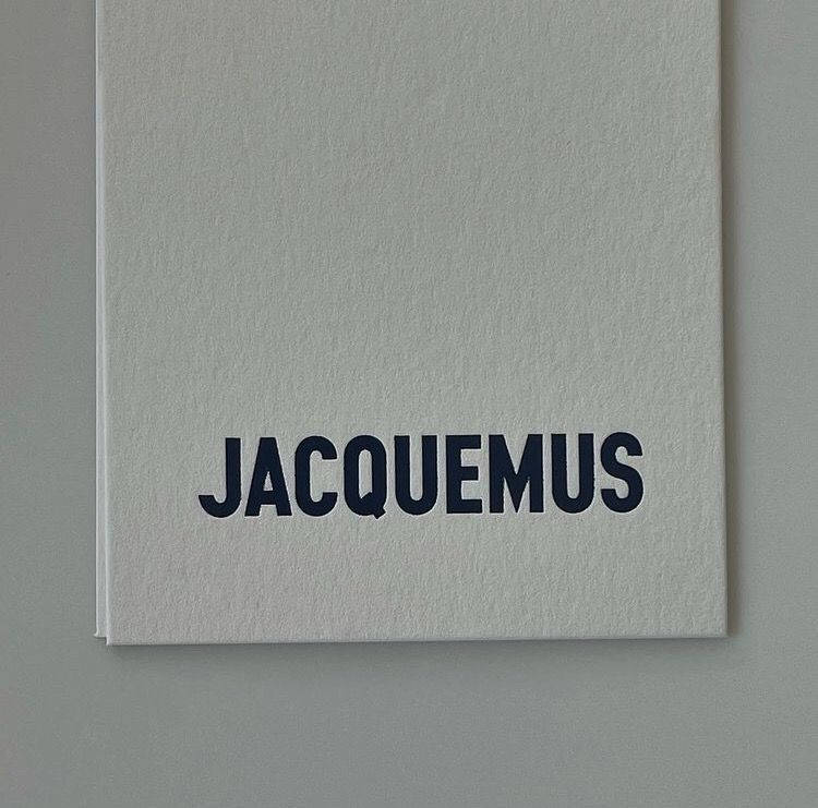 The Iconic Jacquemus Logo On White Paper Wallpaper