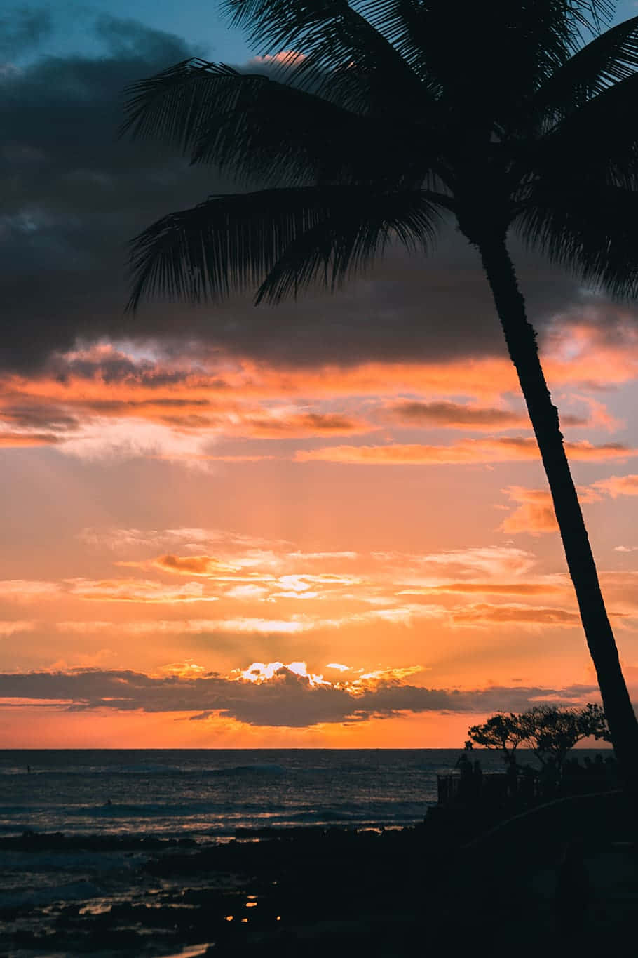 The Sun Setting Over A Stunning Beach In Hawaii Wallpaper