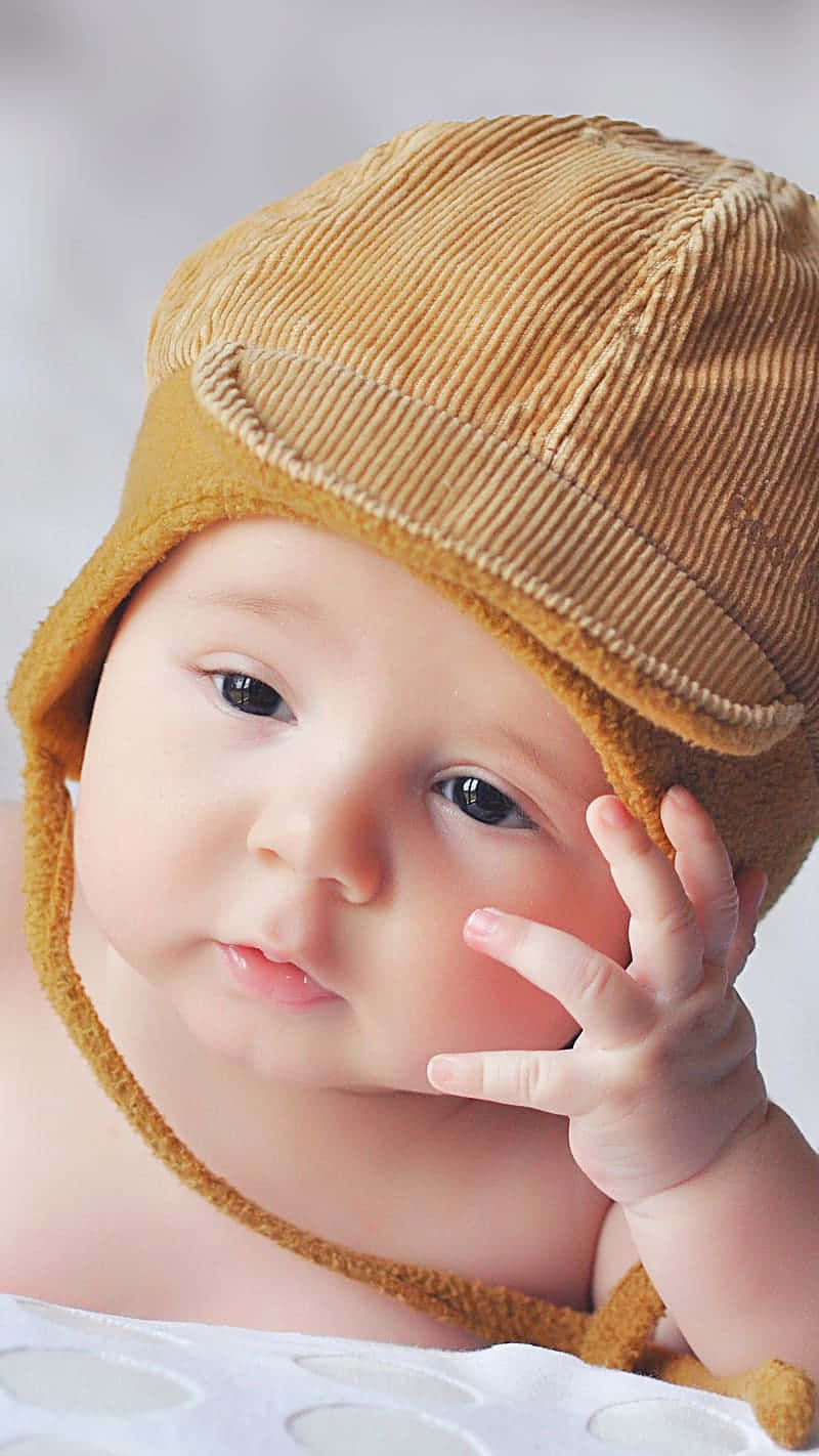 Thoughtful Babywith Brown Hat Wallpaper