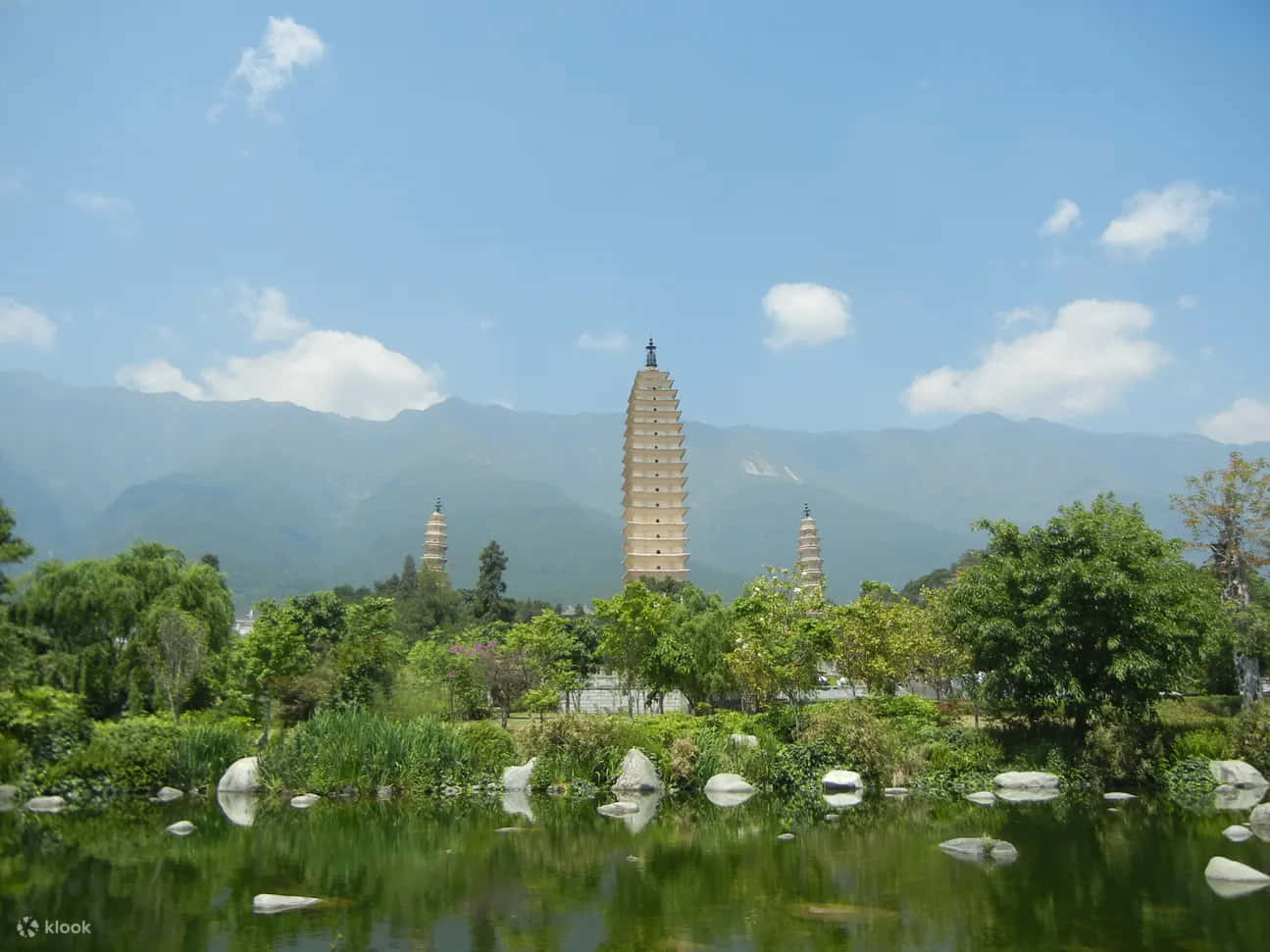 Three Pagodas With Rocks On River Wallpaper