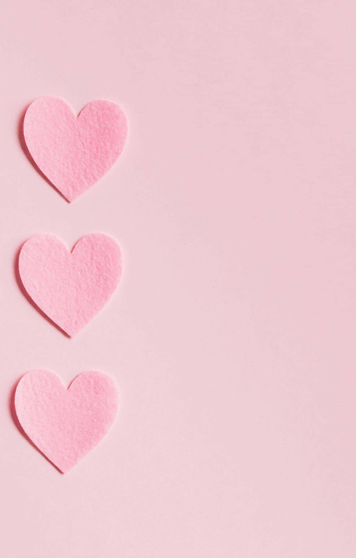 Three Pink Heart Shaped Paper On A Pink Background Wallpaper