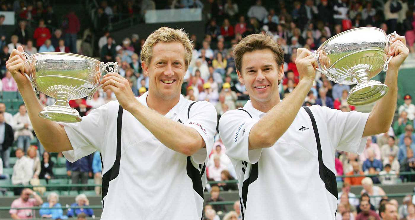 Todd Woodbridge And Partner Celebrating Victory With Trophies Wallpaper