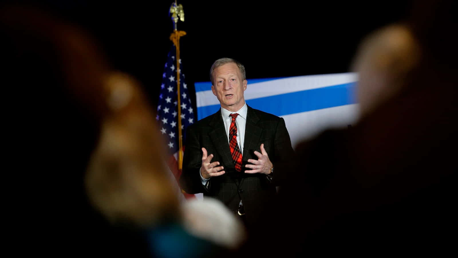 Tom Steyer Beside A Flag Wallpaper