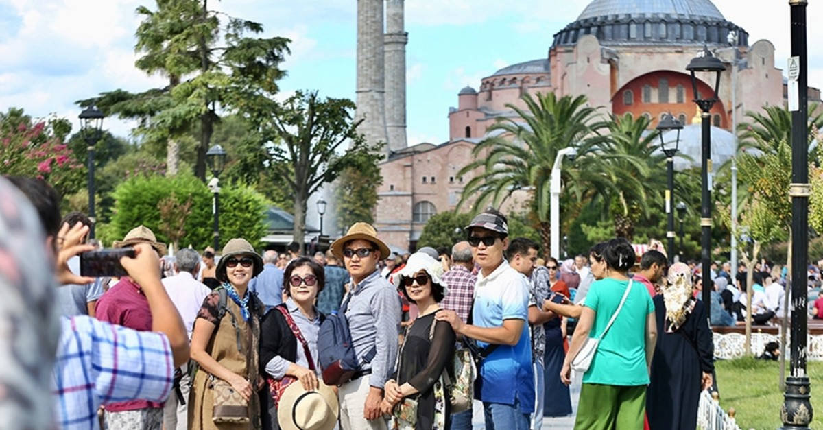 Tourists Exploring The Iconic Hagia Sophia In Istanbul Wallpaper