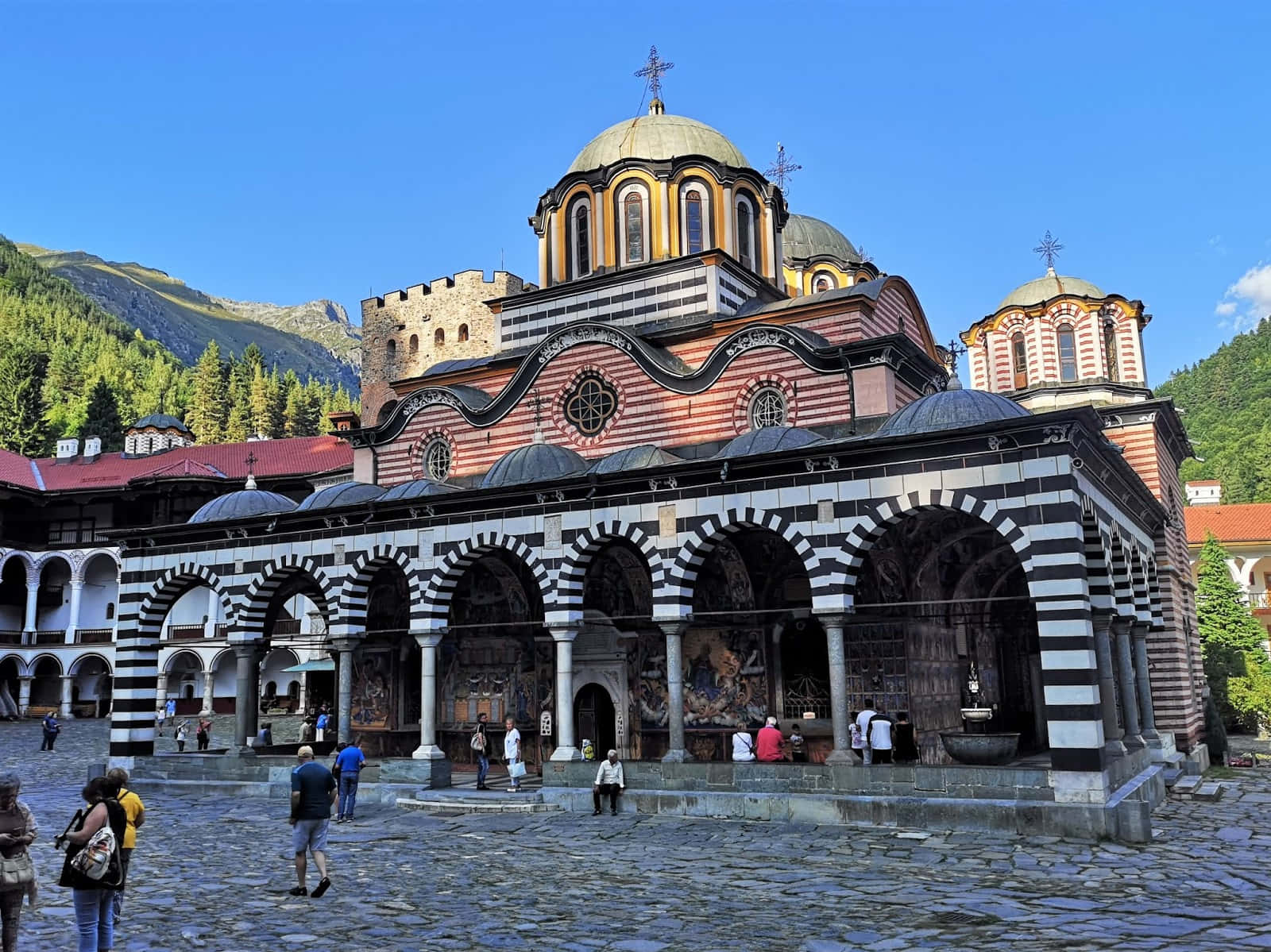 Tourists Exploring The Picturesque Rila Monastery Wallpaper