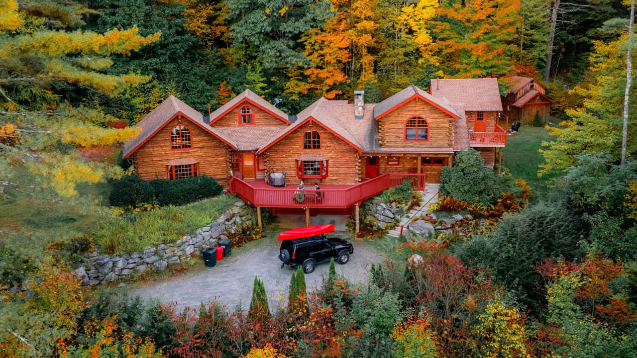 Tranquil Fall Cabin Nestled In Autumn Foliage Wallpaper