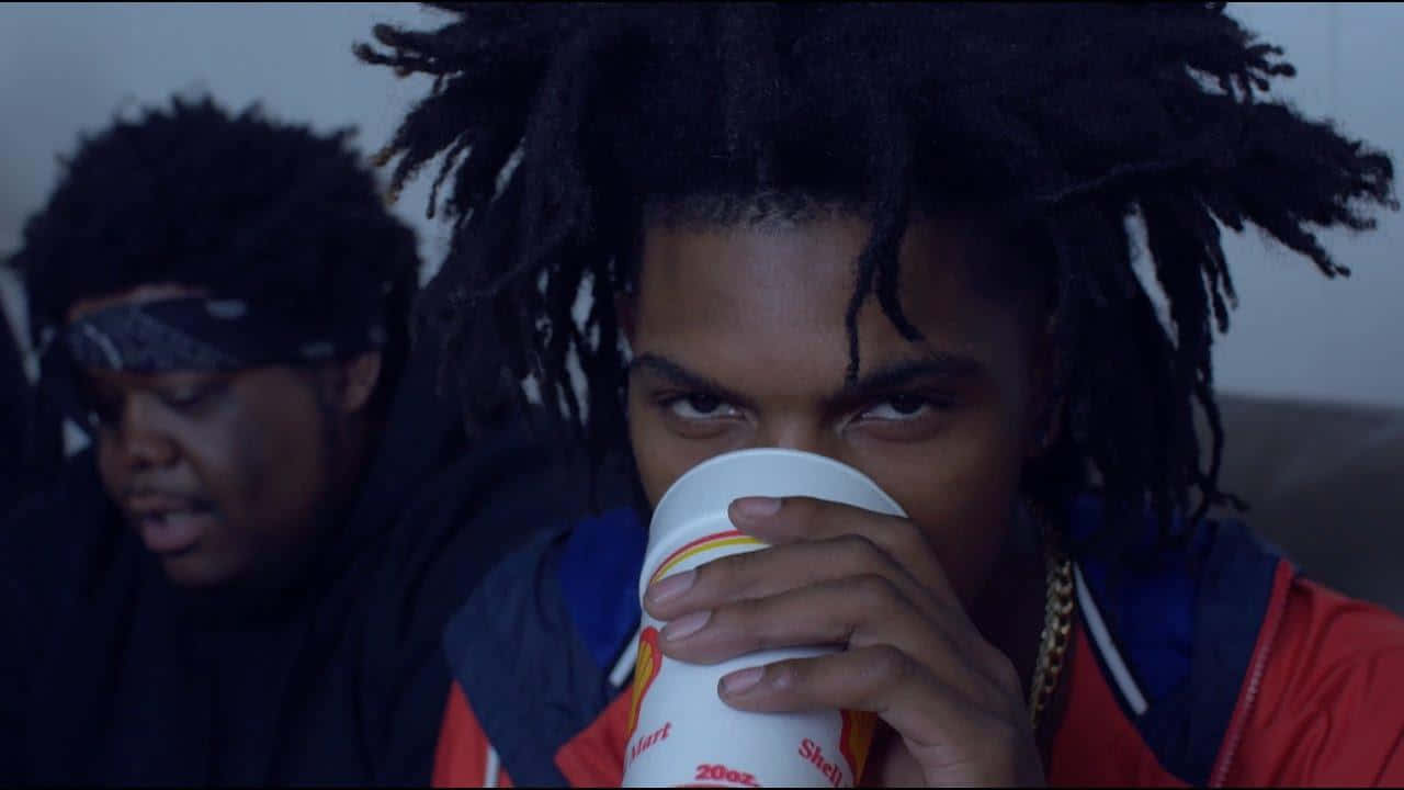 Two Men With Dreadlocks Drinking From A Cup Wallpaper