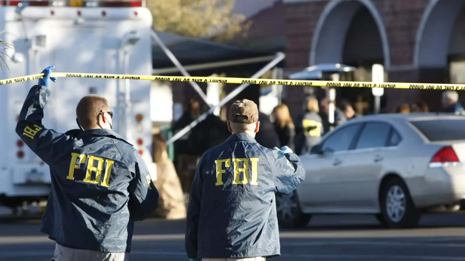 Two Police Officers Standing Near A Police Tape Wallpaper