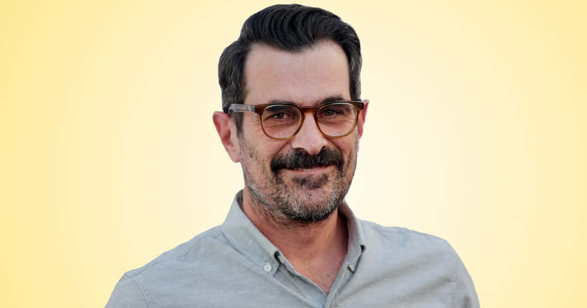 Ty Burrell Smiling On A Blue Background Wallpaper