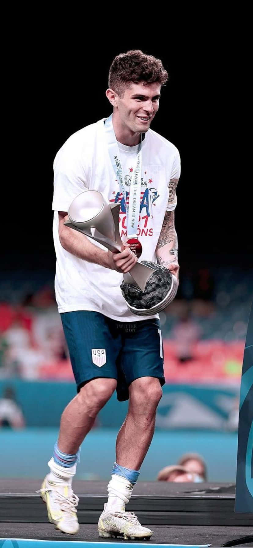 U S Soccer Player Celebrating Victory With Trophy Wallpaper