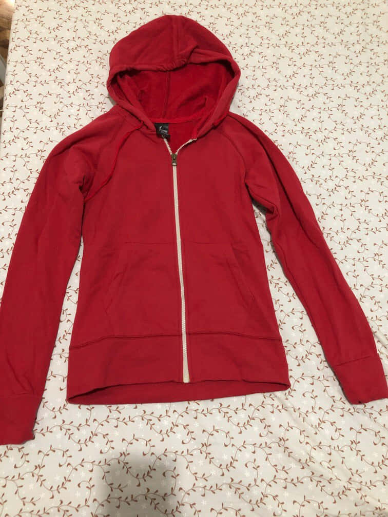 Unisex Red Hoodie Spotlighted On Dark Background Wallpaper