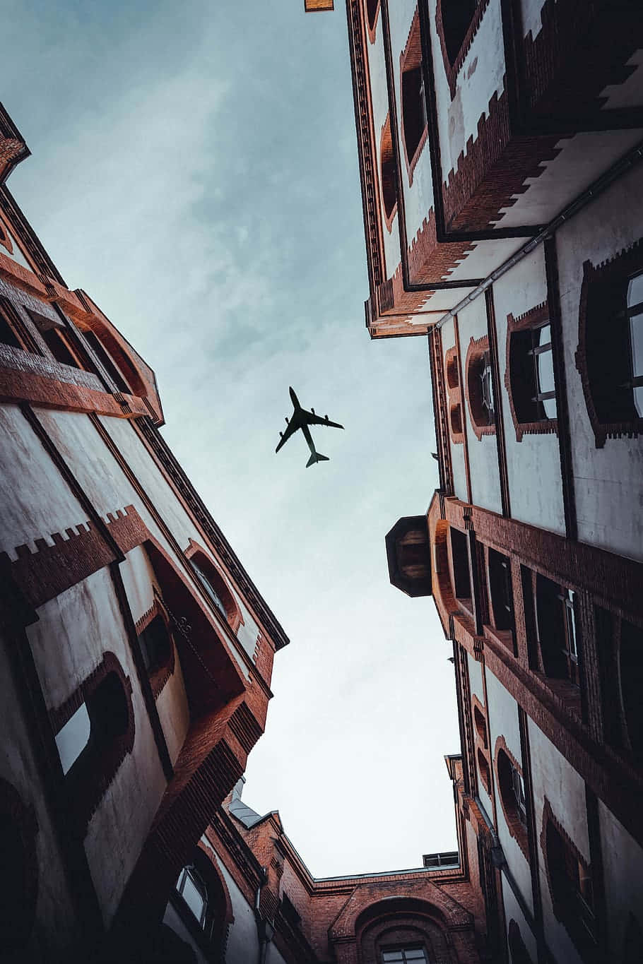 Urban_ Canyon_with_ Airplane_ Above.jpg Wallpaper